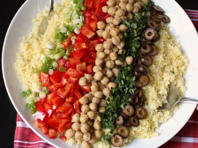 ingredients layered over couscous for salad