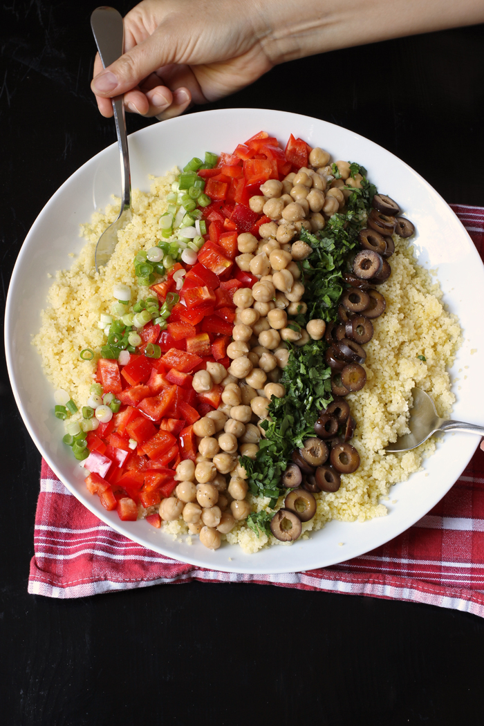 ingredients layered over couscous for salad