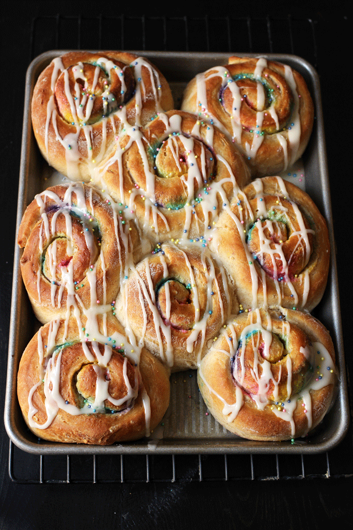 pan of baked and glazed rainbow rolls