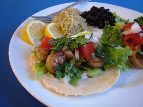 A plate of shrimp taco and rice and beans