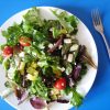 A bowl of salad on a blue table