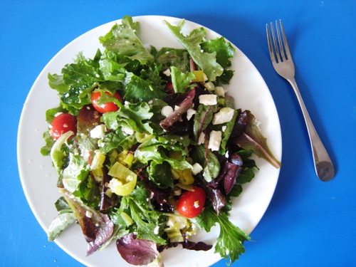 A bowl of salad on a blue table