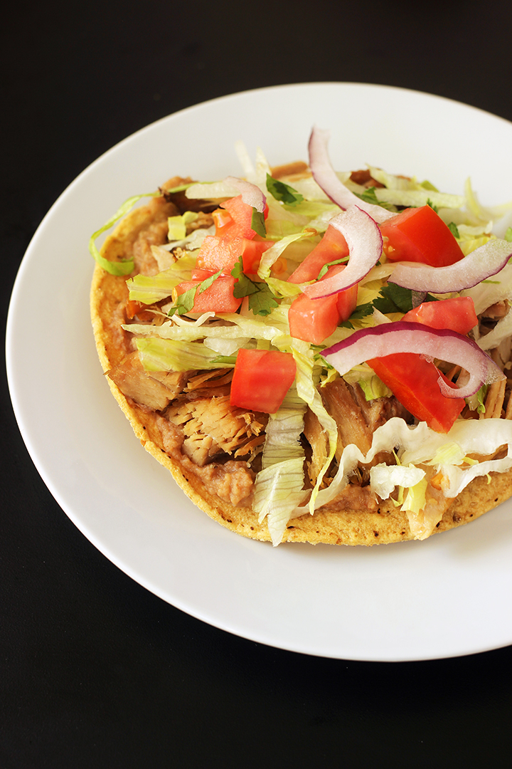 carnitas tostada on white plate