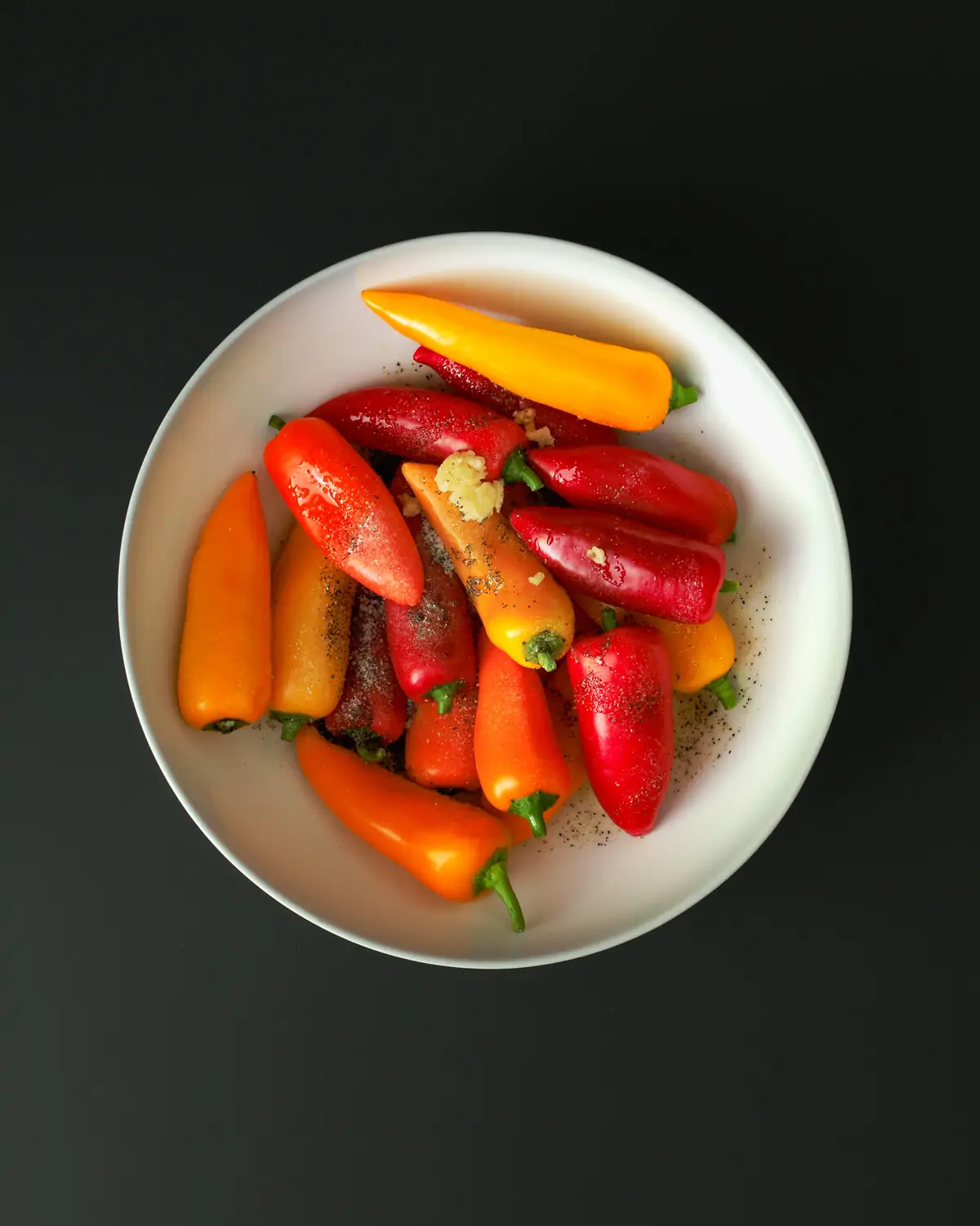 peppers, oil, and seasonings in white bowl.