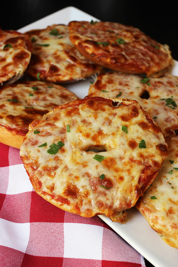 pizza bagels on tray with red checked cloth