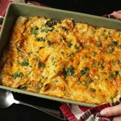 A person holding a baking dish of casserole