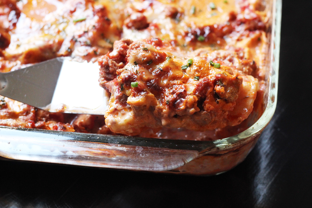 spatula scooping piece of lasagne from pan