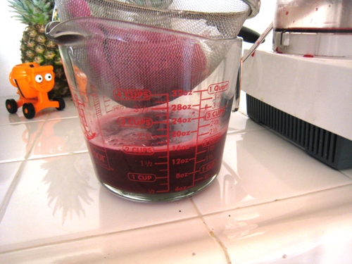 draining pomegranate juice in a glass measure