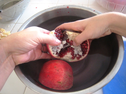 seeding pomegranate in bowl of water