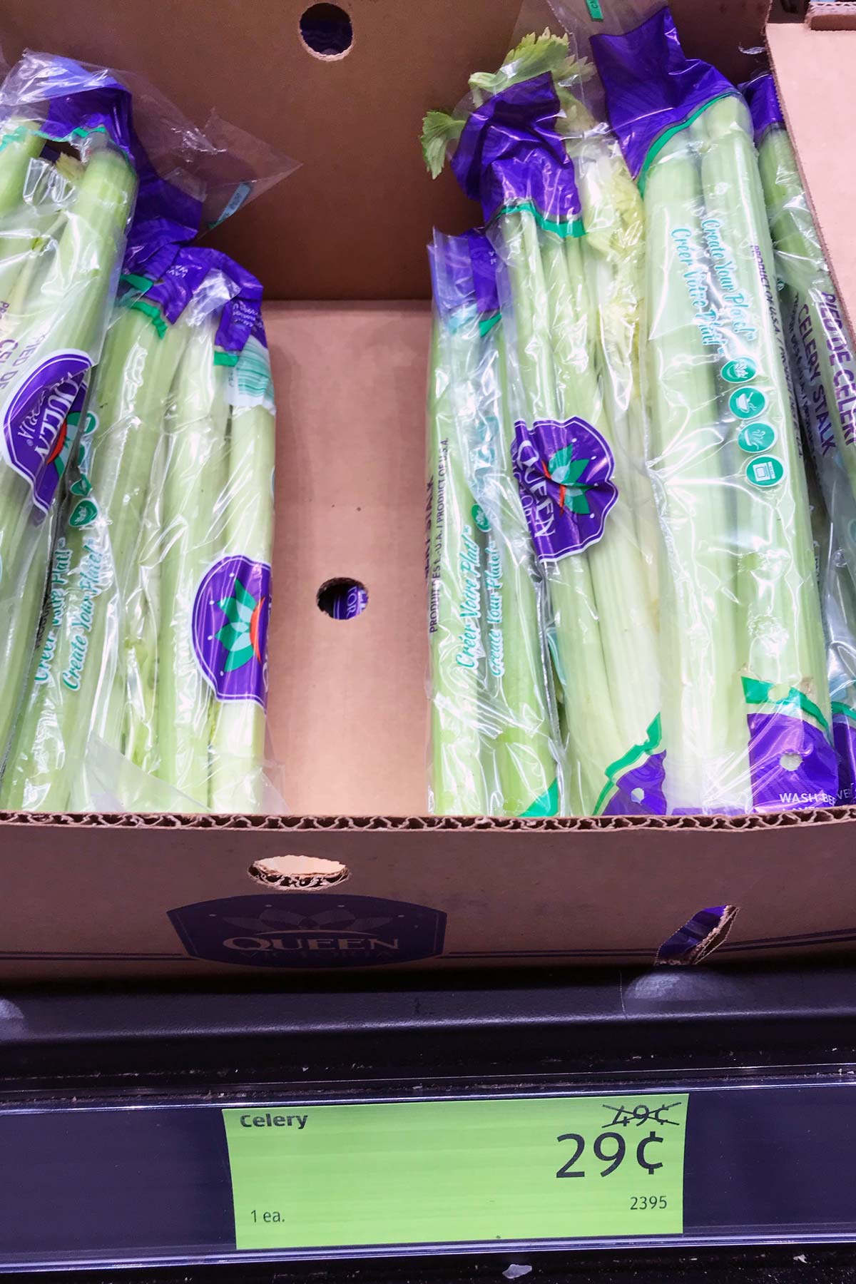 celery in a crate above a christmas clearance price tag.