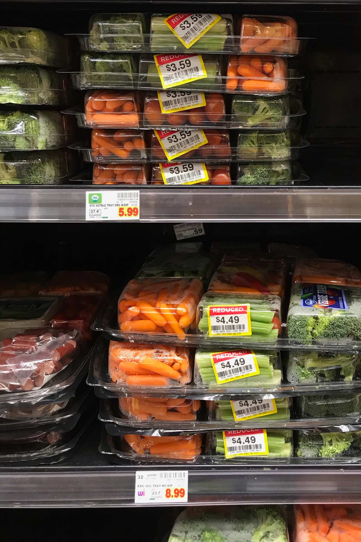 stacks of veggie trays marked down after christmas on grocery store shelves.