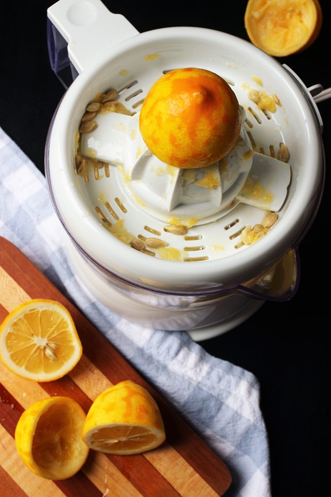 lemon halves on cutting board near juicer