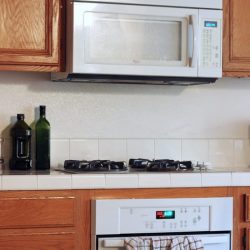 A kitchen with wooden cabinets and a microwave