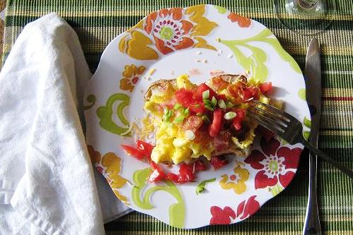 loaded breakfast potato with toppings on a plate 