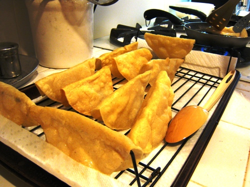 fried taco shells draining on rack