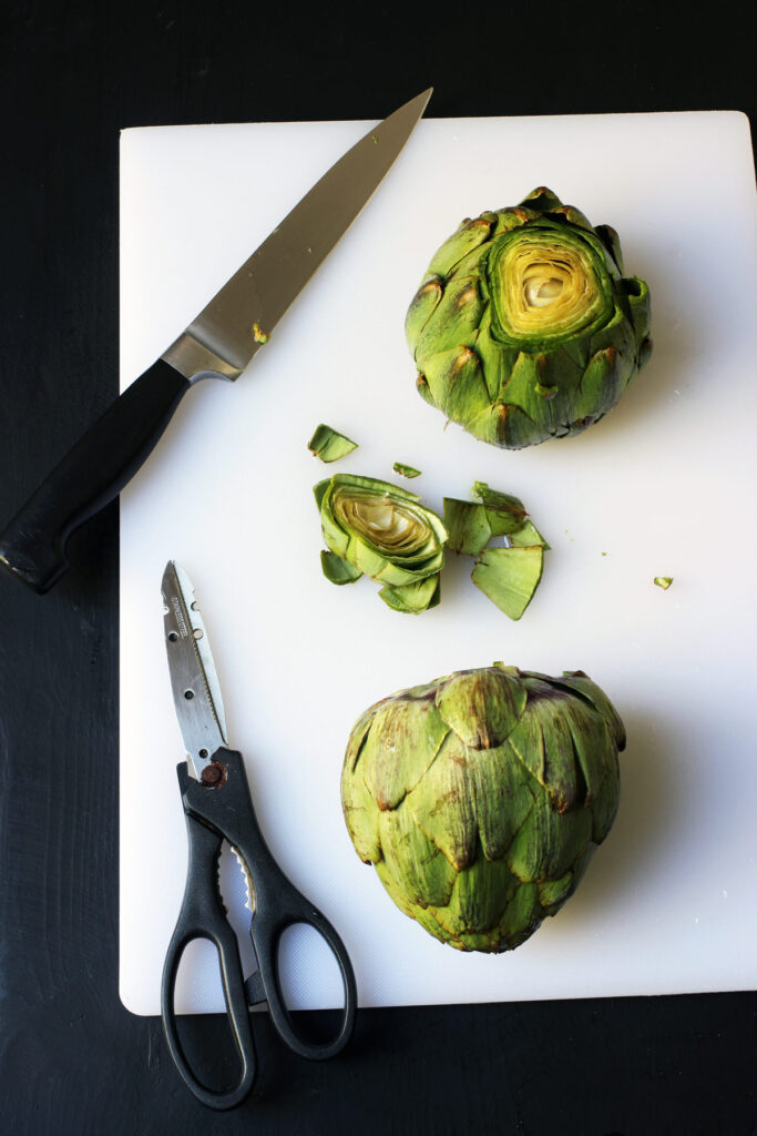 cutting off tip of artichokes