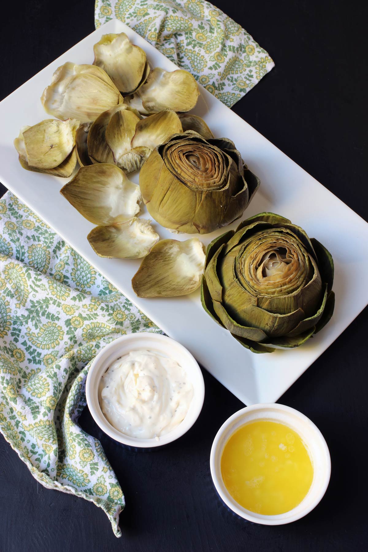 platter of artichokes with dipping sauces