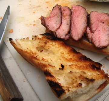 open halves of tri-tip sandwich on a cutting board