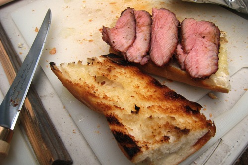 open halves of tri-tip sandwich on a cutting board
