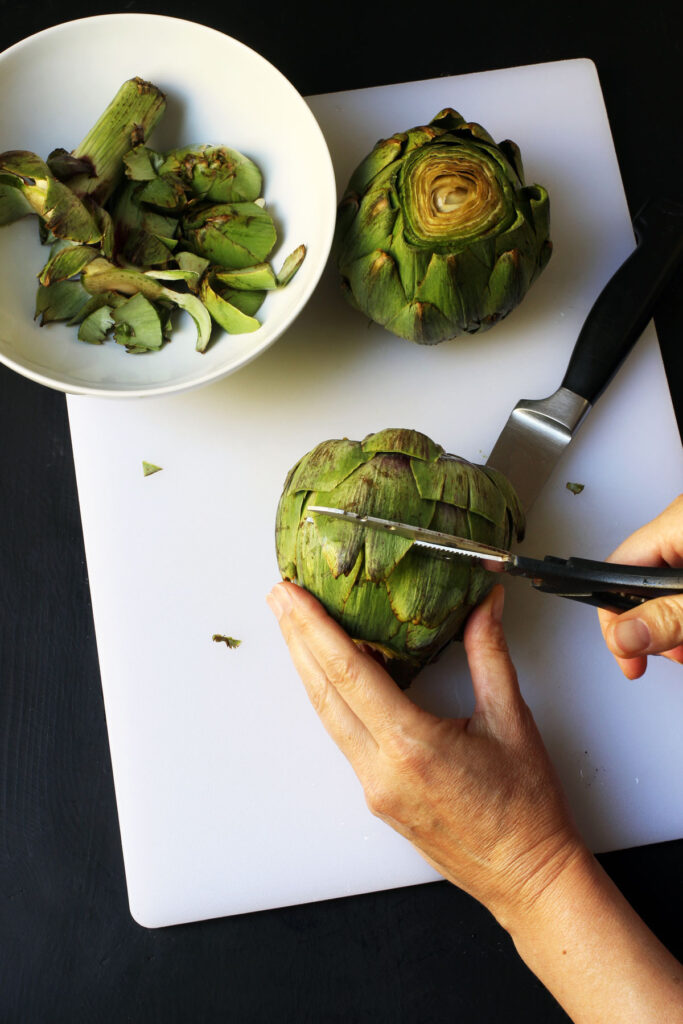 trimming artichoke leaves with scissors