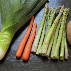 leek carrots asparagus and potatoes on a black table