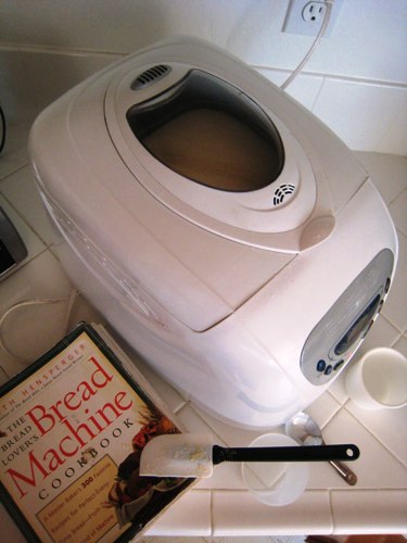 bread machine on counter with cookbook