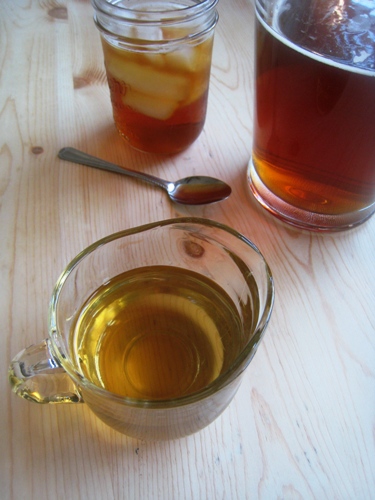 A pitcher of simple syrup next to tea