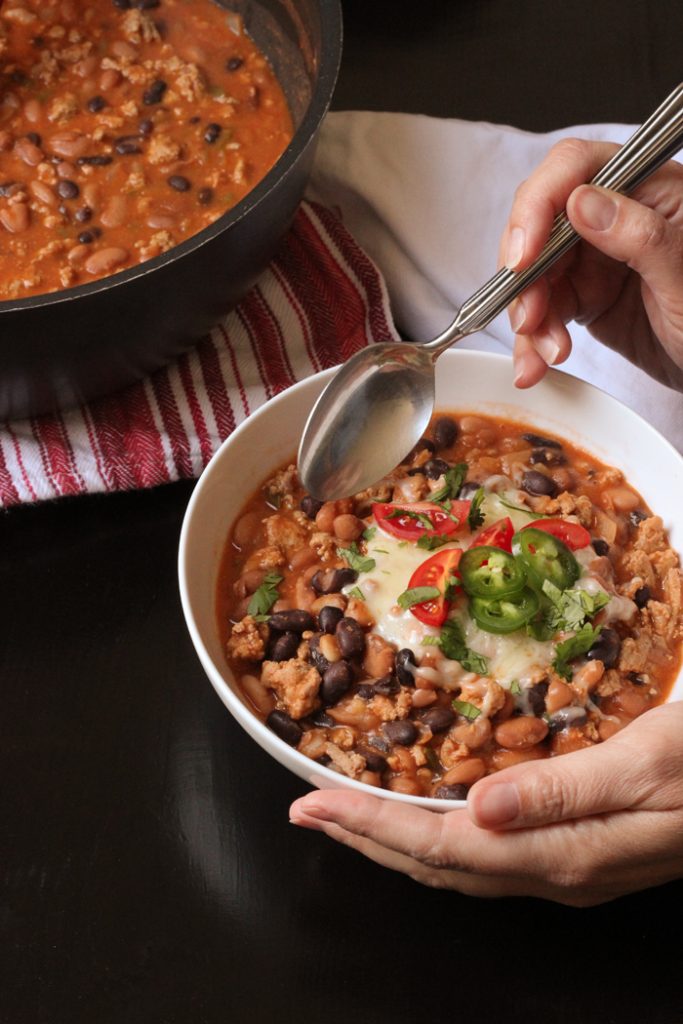 A bowl of chili with toppings