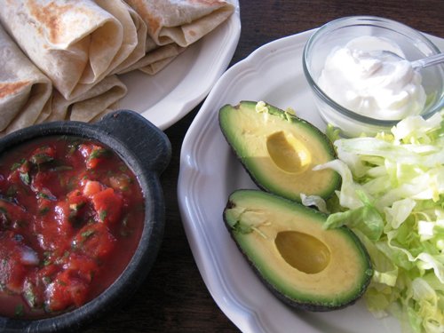 plate of avocados and other burrito toppings