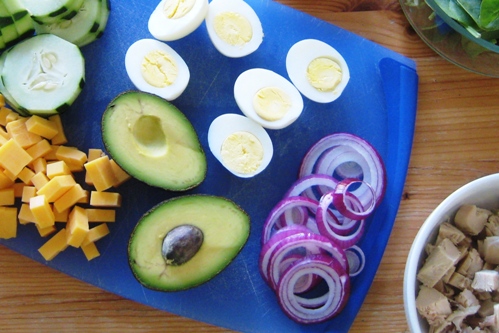 eggs, avocado, and onion sliced on cutting board