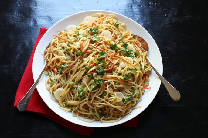 A bowl of Noodle Salad, with serving spoons