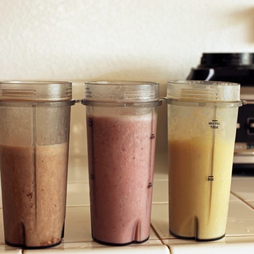 blender cups with different types of smoothie