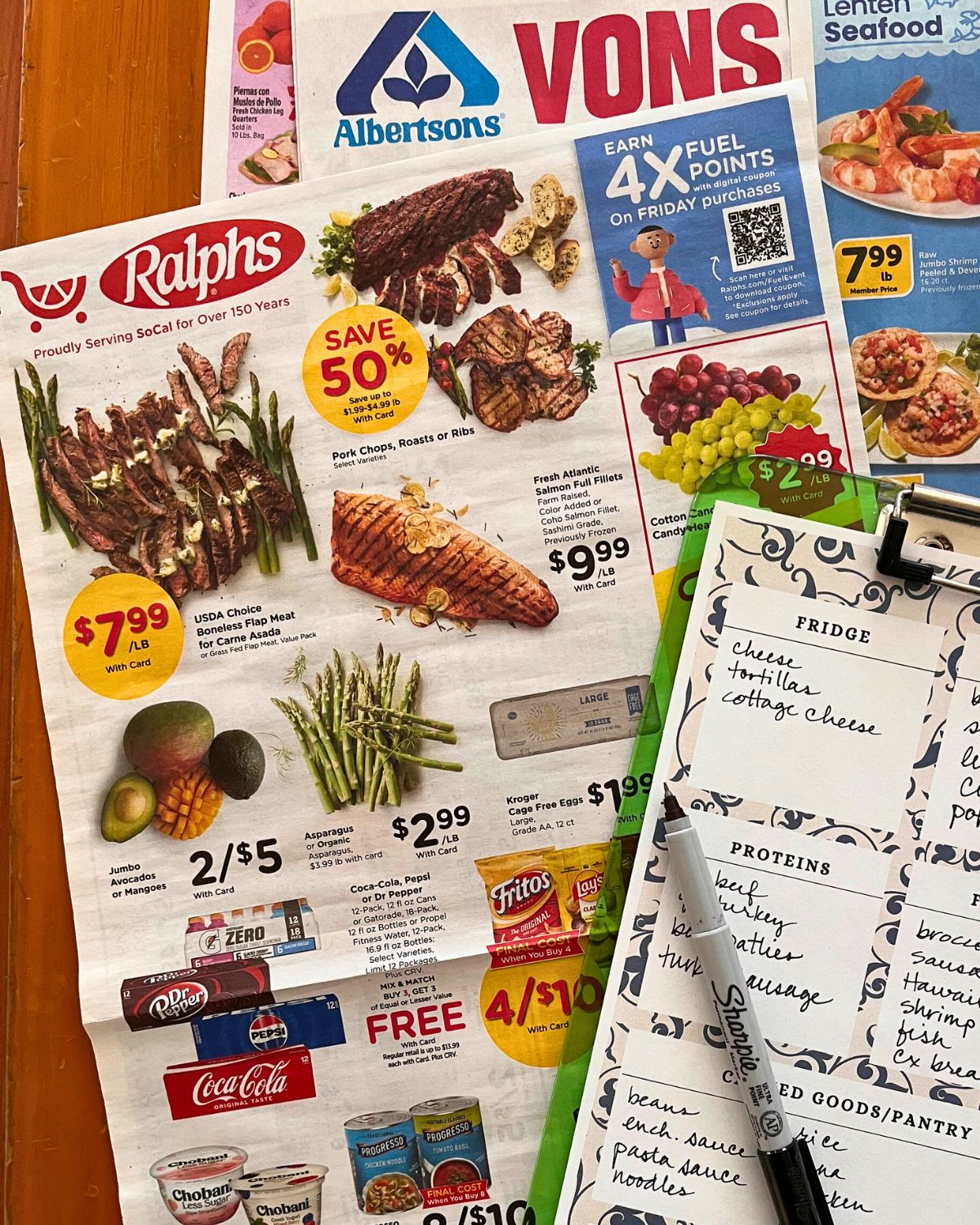 grocery store sales ads on table with clipboard of inventory.