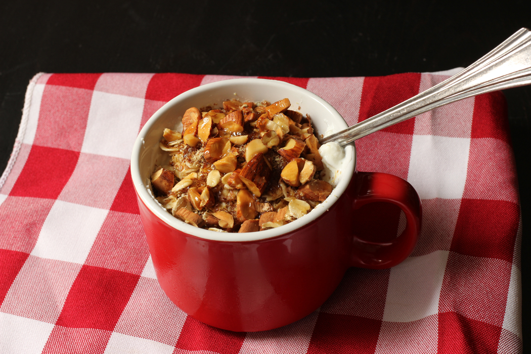 red mug of yogurt oats and nuts on gingham napkin