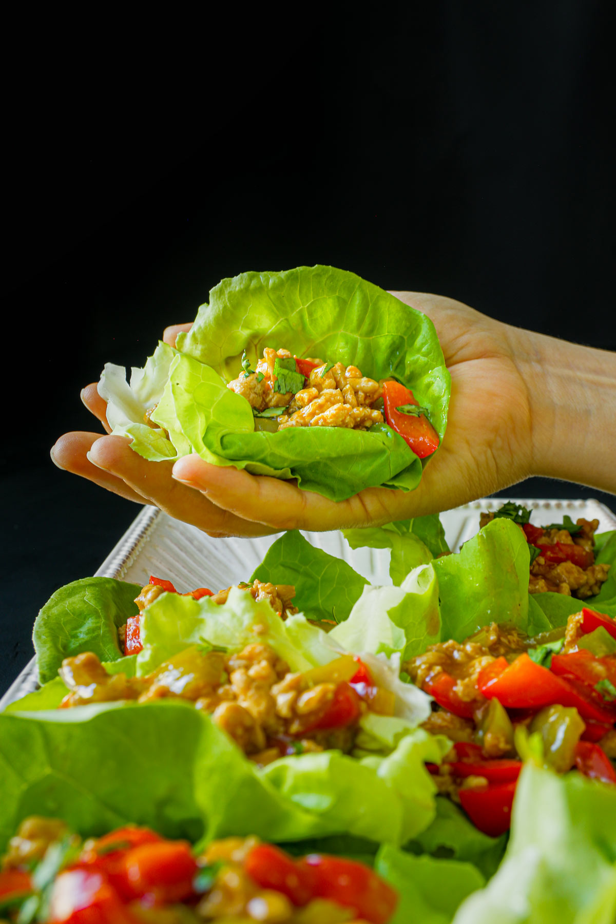 hand holding a lettuce leaf for turkey lettuce wraps.