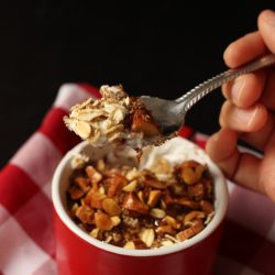 A person holding a spoon of yogurt and muesli