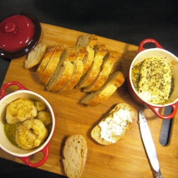roasted garlic and baked goat cheese on wooden board