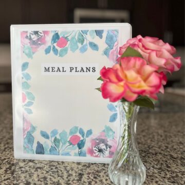 meal plan binder and flowers on counter.