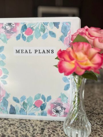 meal plan binder and flowers on counter.
