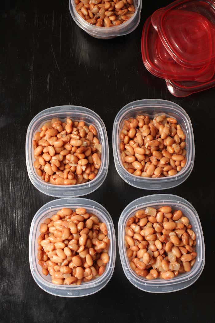 cooked pinto beans divided into containers for freezing