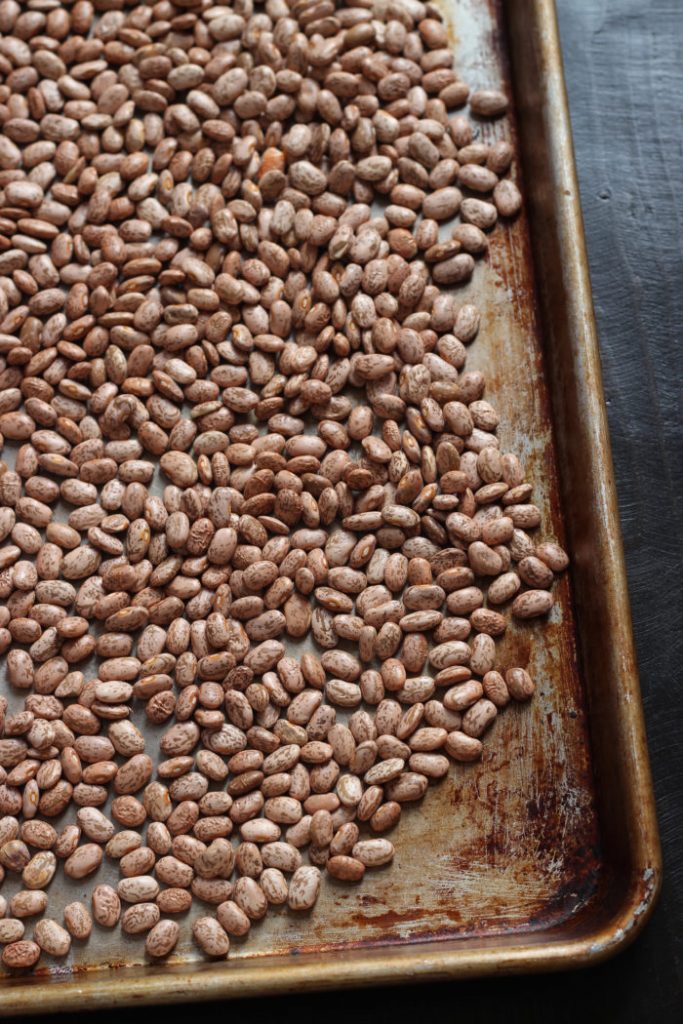 pinto beans being sorted on baking sheet