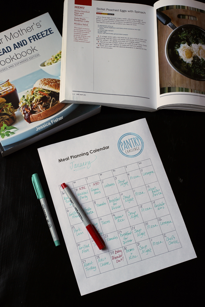 monthly meal planning calendar with pens and cookbooks