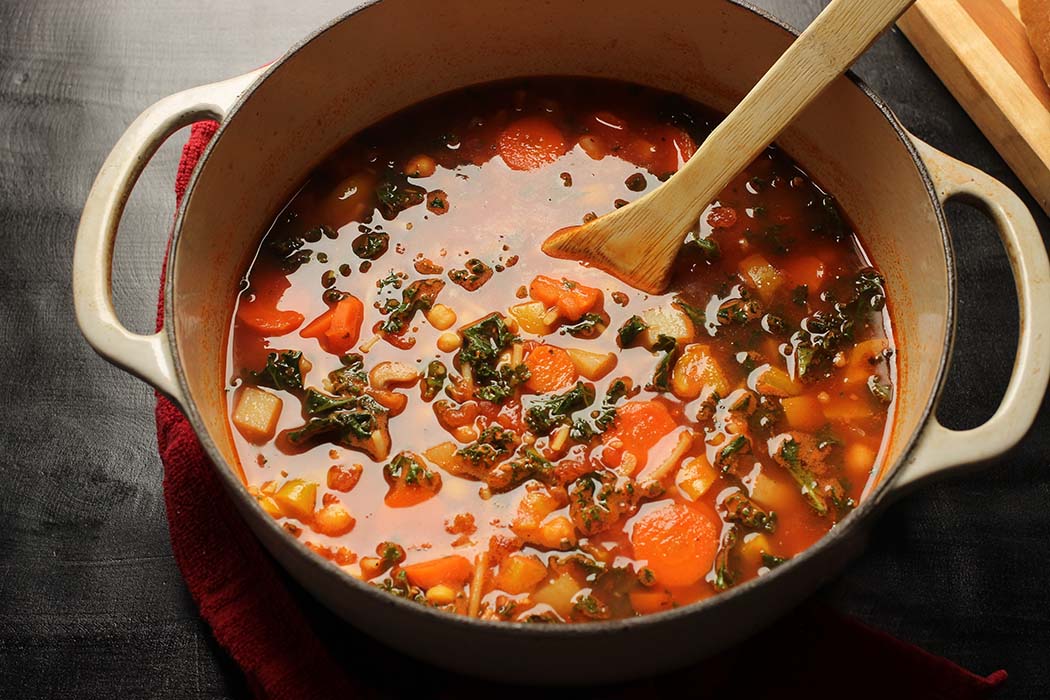 pot of minestrone with wooden spoon