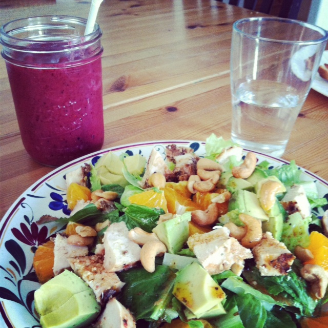 A plate of salad with a glass of smoothie