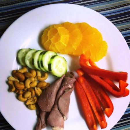 A plate of fruit, veg, nuts, and meat