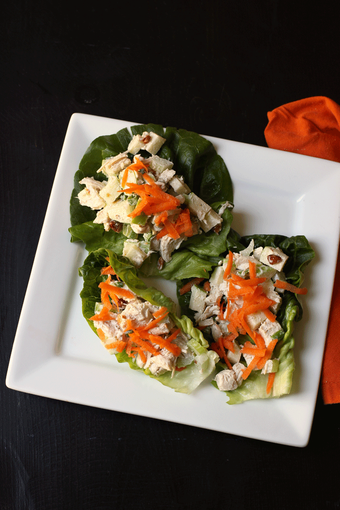 chicken salad piled into lettuce leaves and topped with carrot