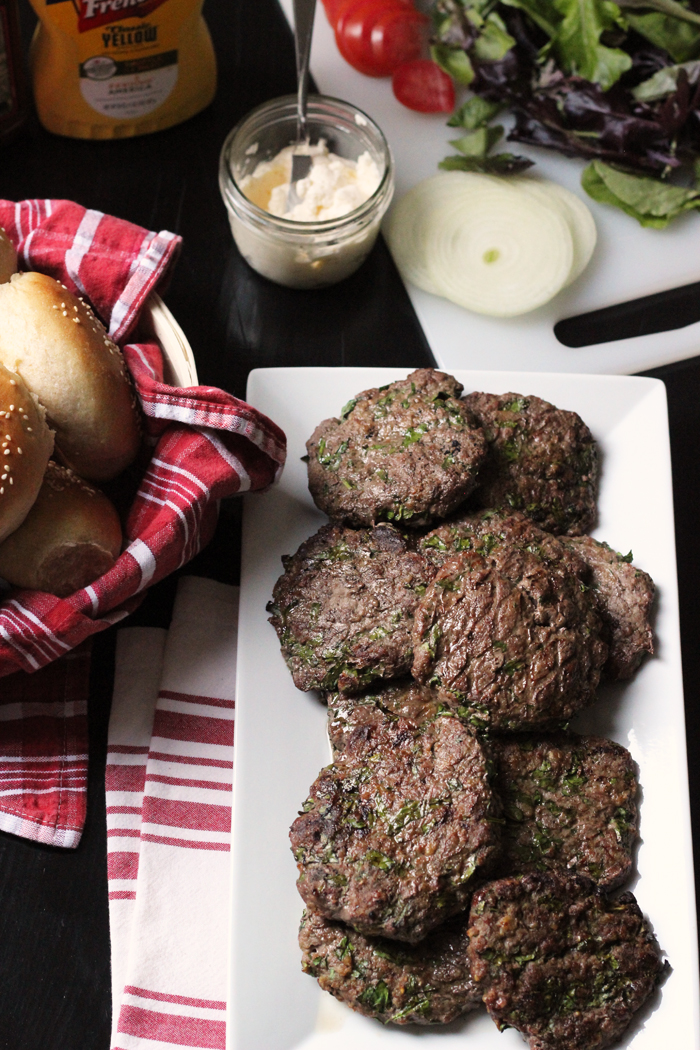 platter of burgers and basket of buns on table