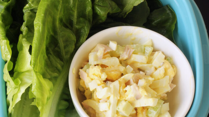 dish of ham and egg salad with lettuce leaves