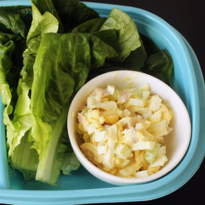 dish of ham and egg salad with lettuce leaves