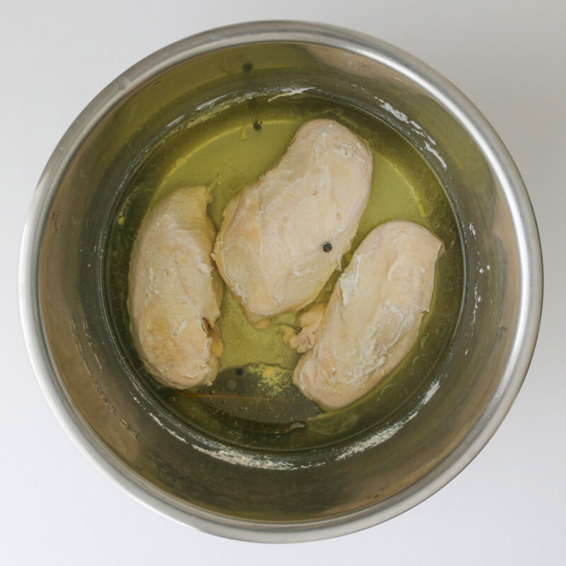 the cooked chicken breasts in the pot.